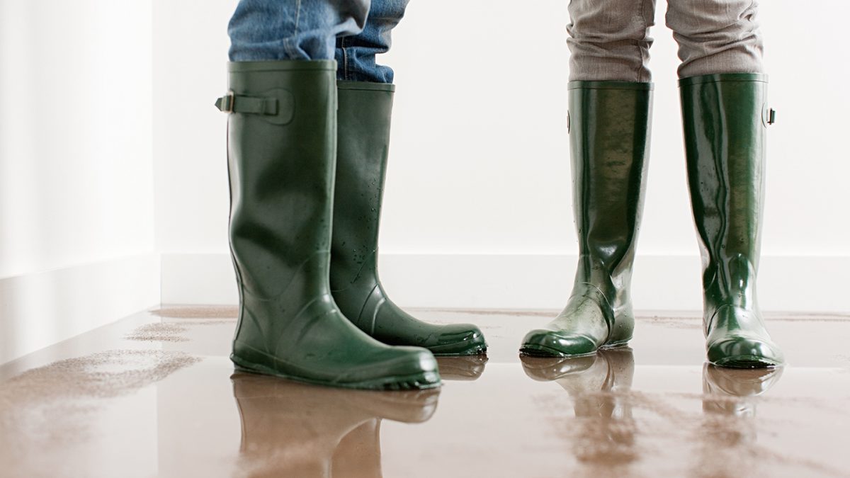 People standing inside a flooded room.