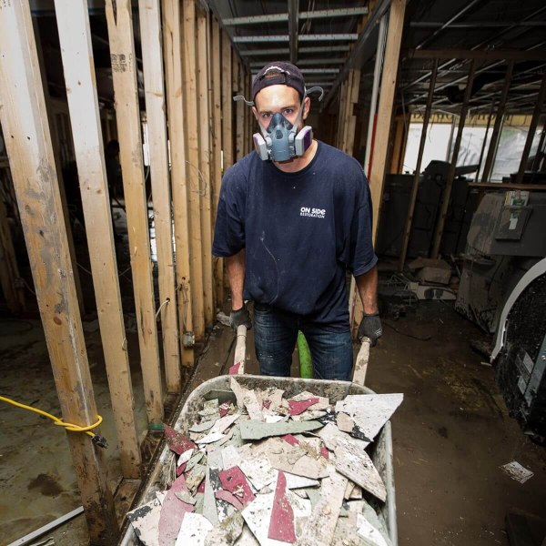 Removing broken tiles of a home after a flood in Canada